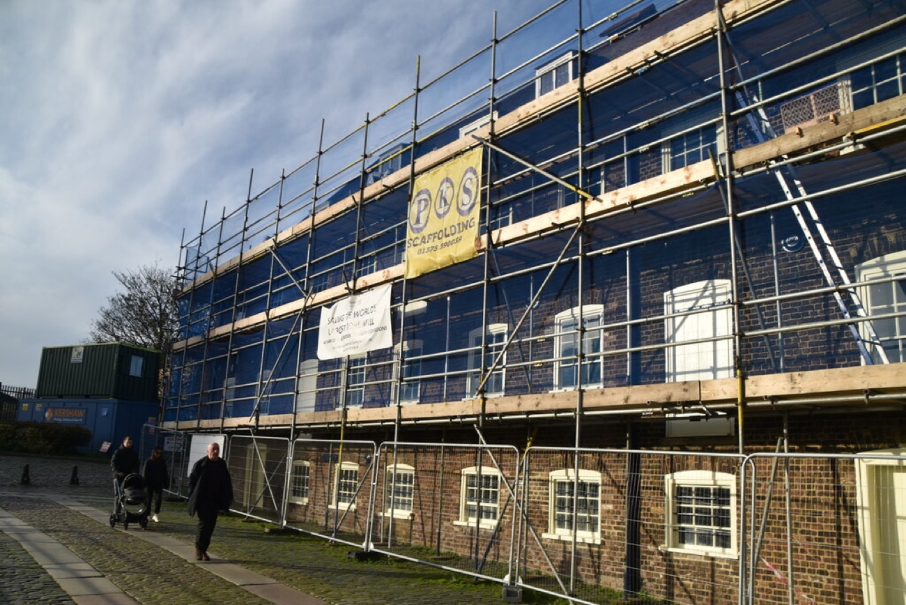 The House Mill under scaffolding during restoration work, with a "Save the World's Largest Tidal Mill" banner.